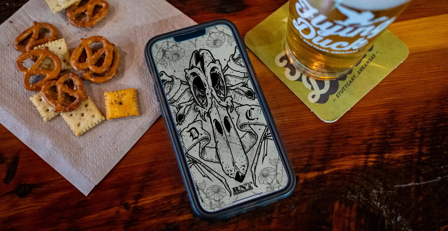 A black smartphone displaying a detailed black-and-white skull illustration.