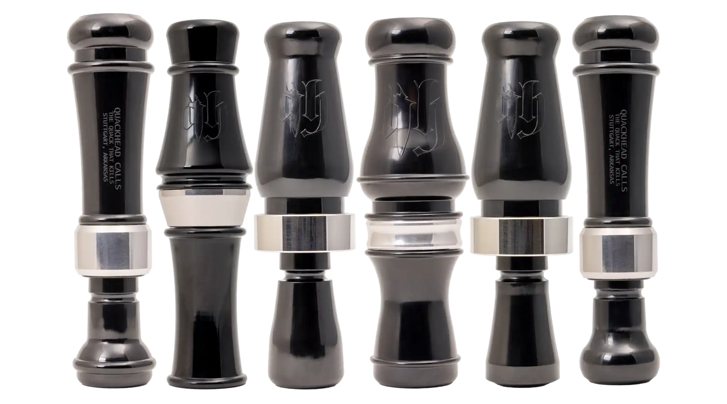 A row of six black duck calls with silver bands.