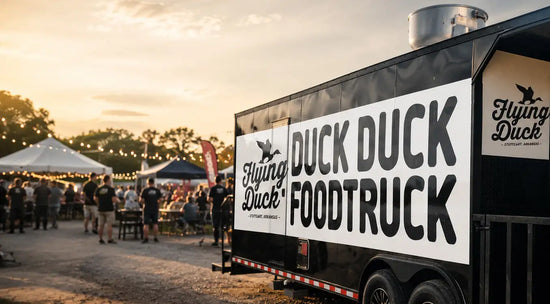 Black food truck with white ’duck duck foodtruck’ branding and a flying duck logo.